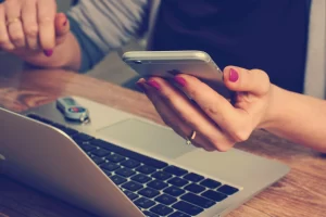 lady working on a mobile and laptop